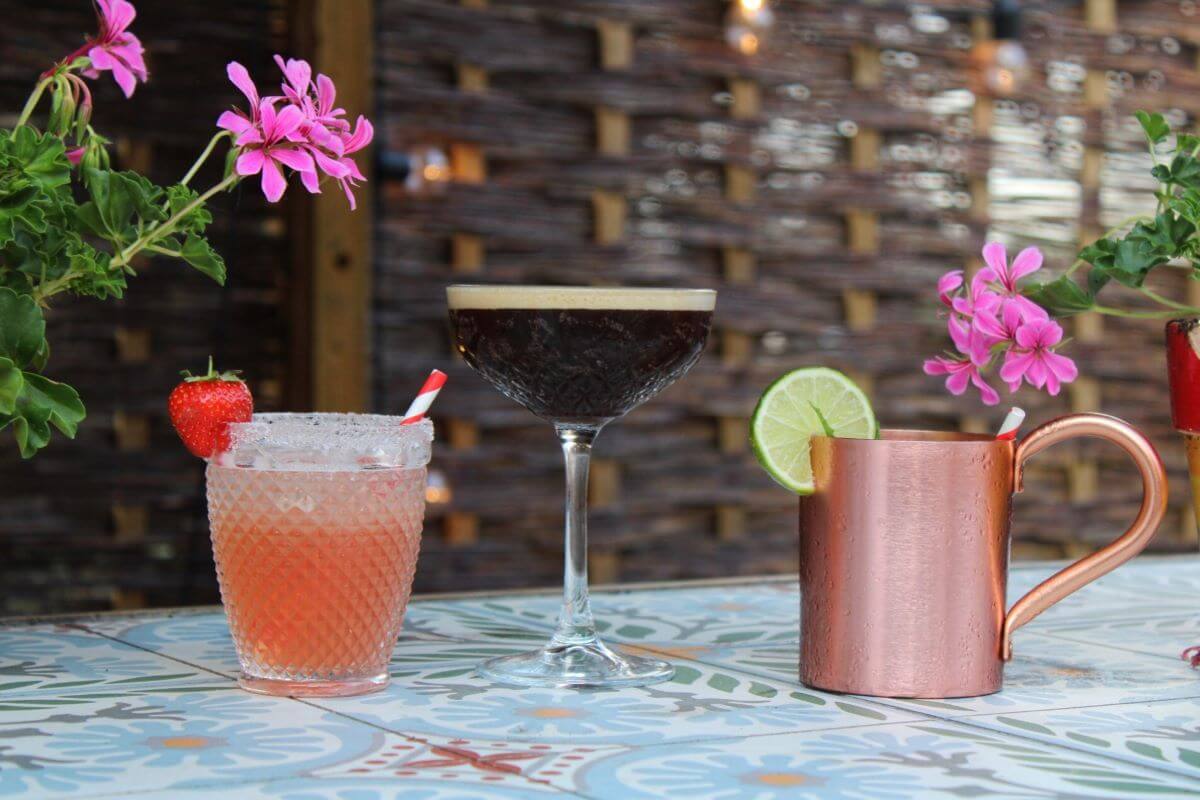 Three cocktails on an outdoor tables