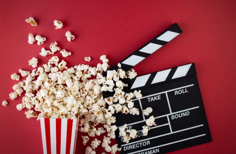 Popcorn and clapper board on a red background, film