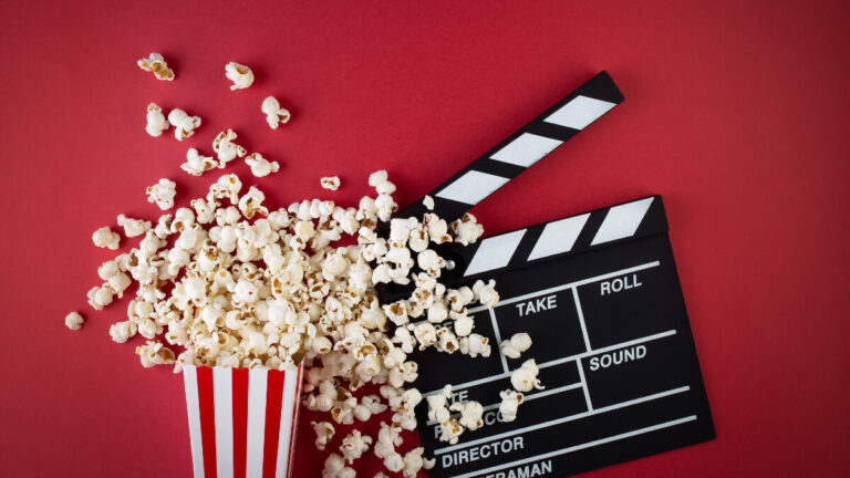 Popcorn and clapper board on a red background, film