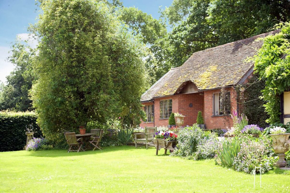 Long Cover Cottage in the sunshine surrounded by trees