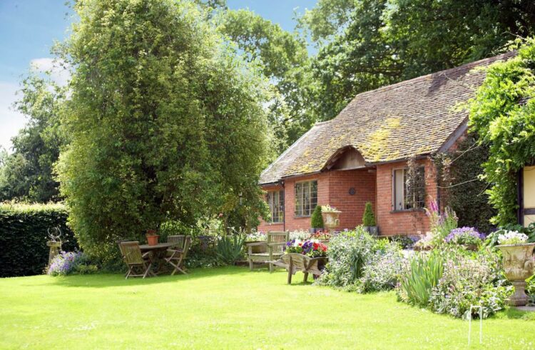 Long Cover Cottage in the sunshine surrounded by trees