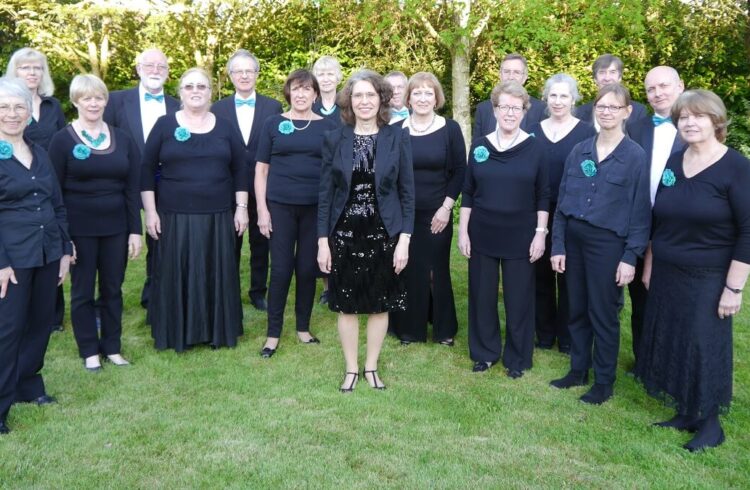 The Hills Singers standing on grass with trees in the background