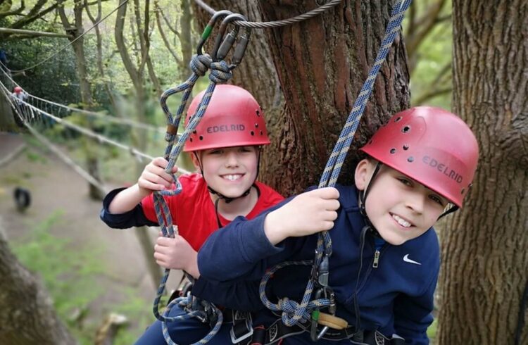 Two boys smile while on high ropes activity