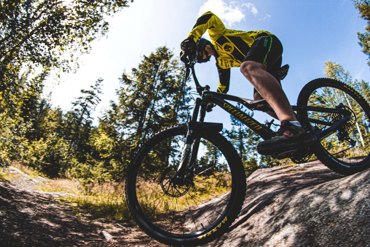 A man mountain biking through a forest