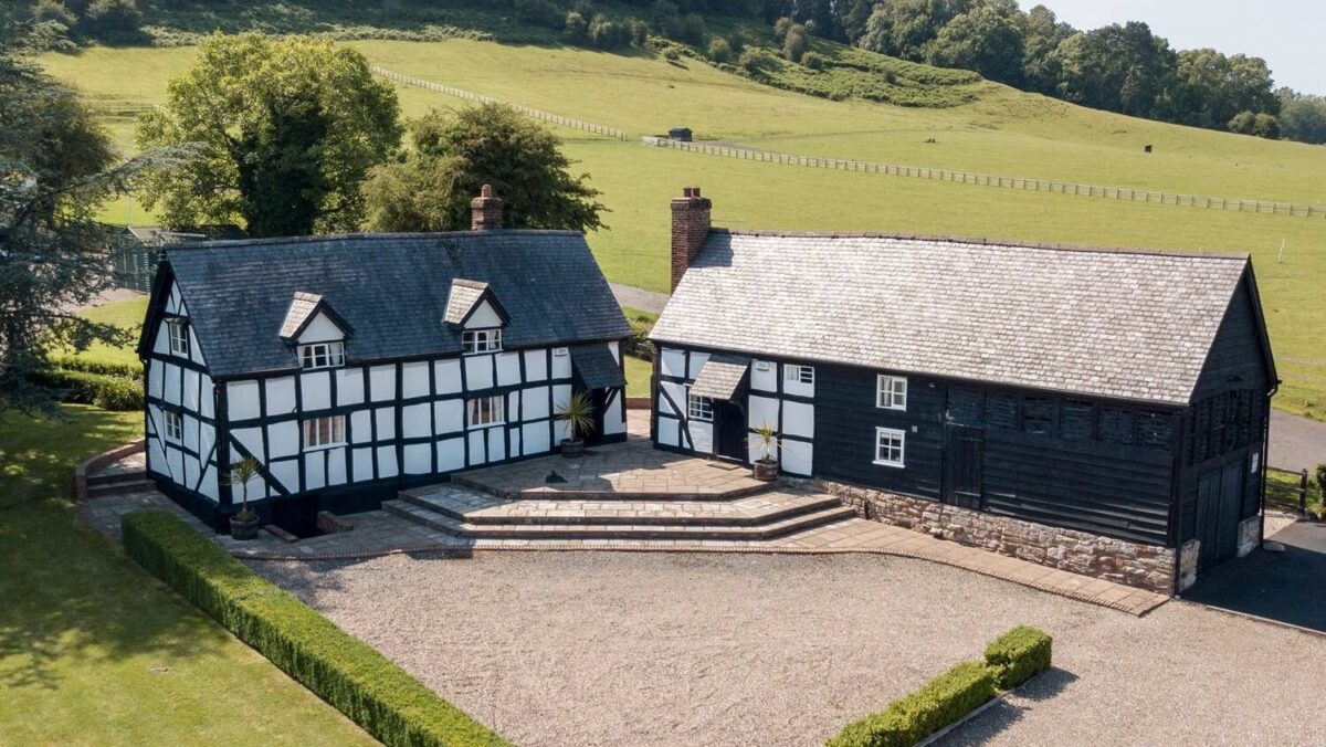 Exterior of cottages with parking area at the front and fields behind