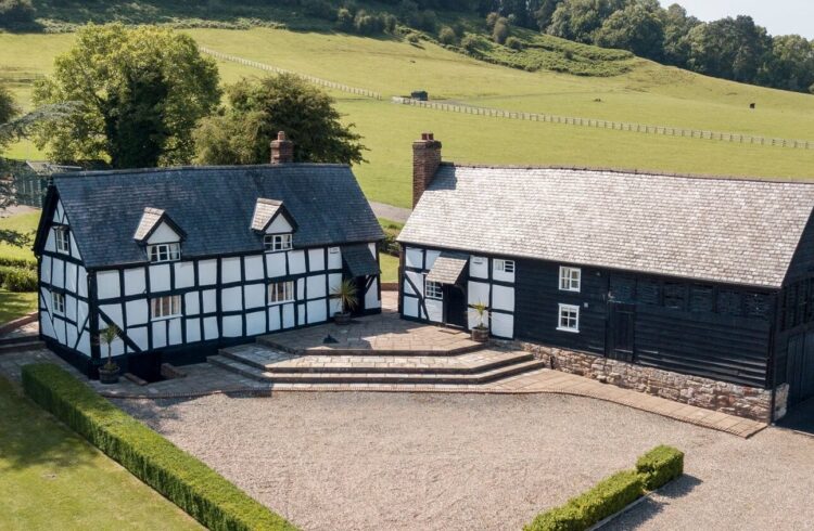 Exterior of cottages with parking area at the front and fields behind