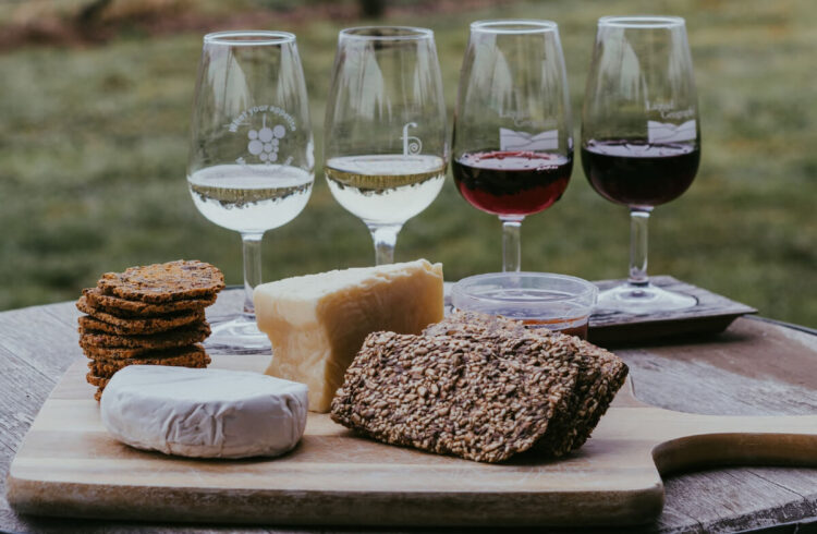 4 wine glasses with different coloured wines, and nibbles infront.