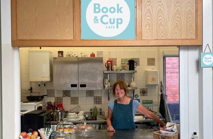 The kitchen and counter at Book and Cup Cafe, with sweet items and fruit on display