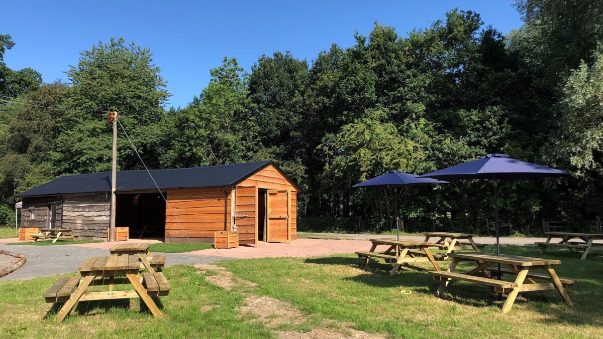 The Woodshed with picnic benches and parasols