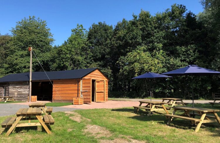 The Woodshed with picnic benches and parasols