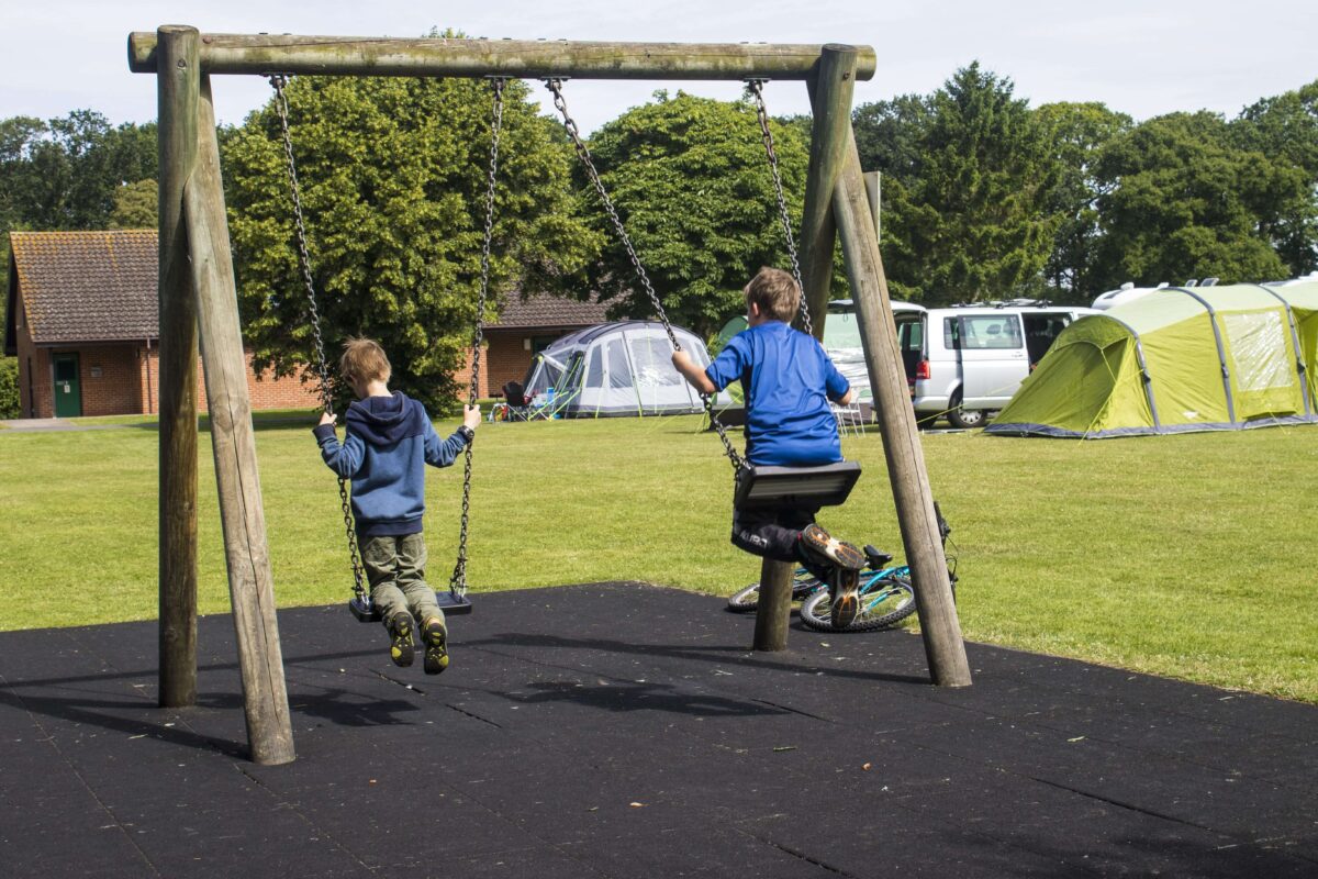 Two children in a wooden swing frame