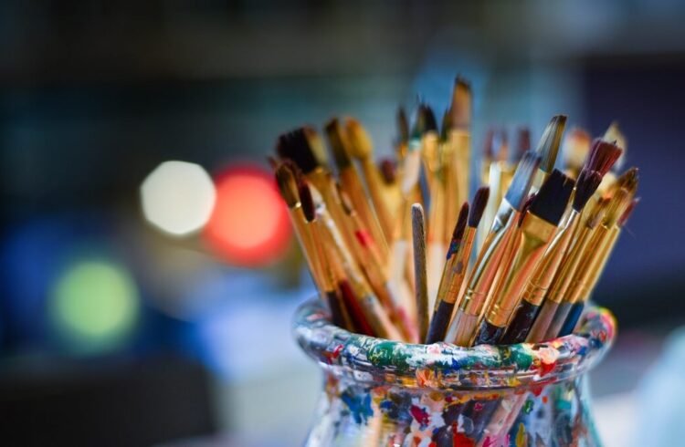 A selection of paintbrushes of various sizes stored in a container