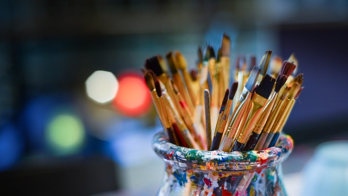 A selection of paintbrushes of various sizes stored in a container