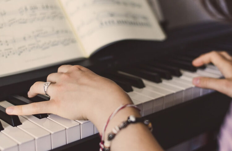 A person wearing bracelets playing a piano