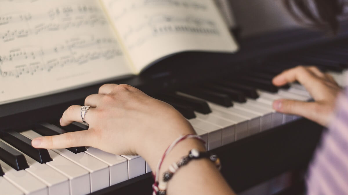 A person wearing bracelets playing a piano