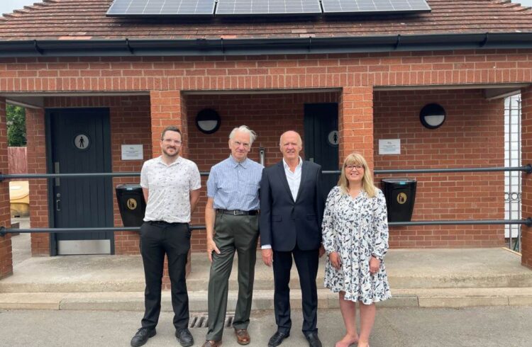 Four people stand outside refurbished public toilets in Tenbury Wells