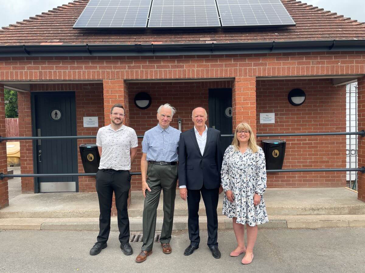 Four people stand outside refurbished public toilets in Tenbury Wells