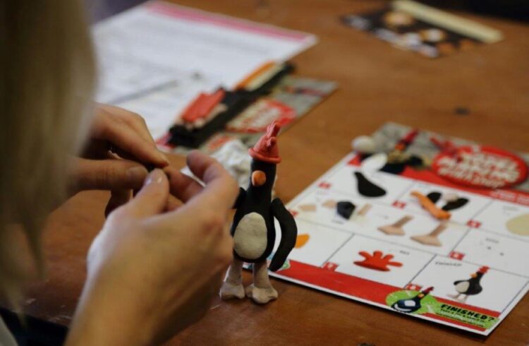 Hands making a model of an evil penguin