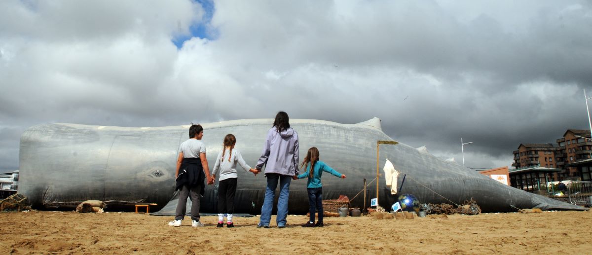 A family looking at a fake beached whale