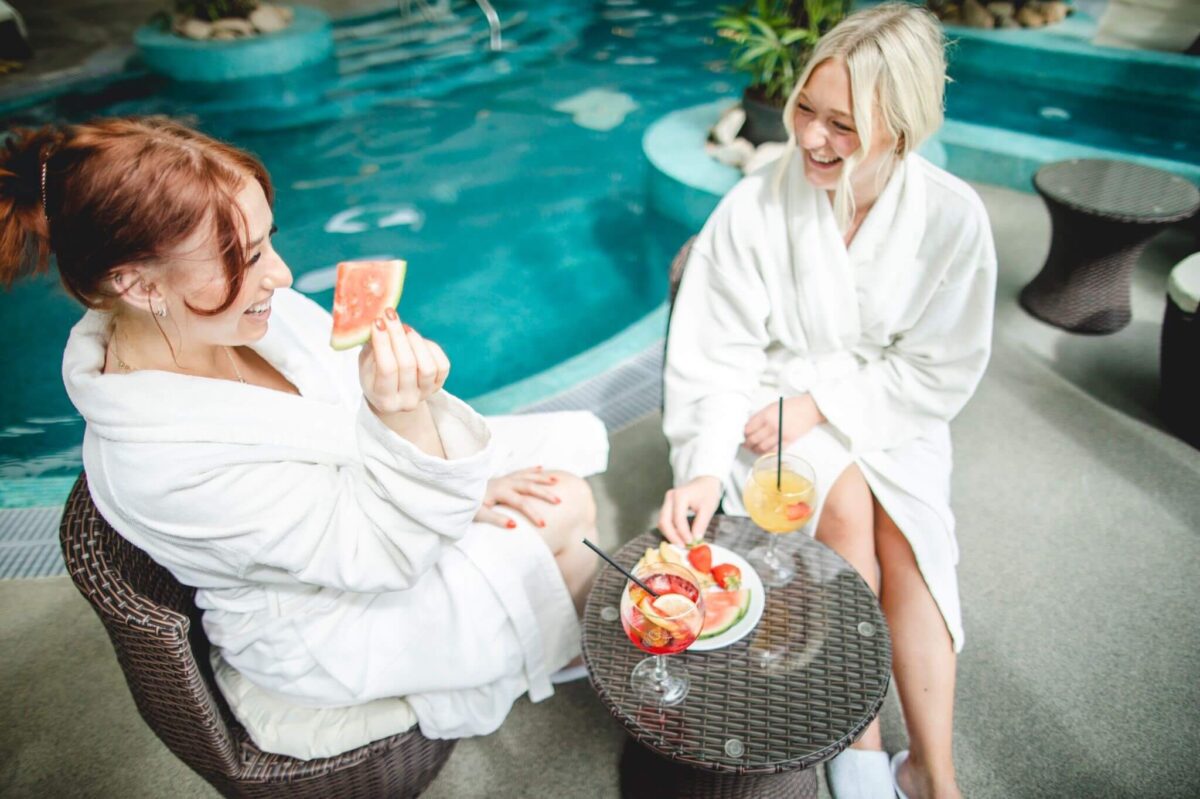 Two people eat watermelon at a spa