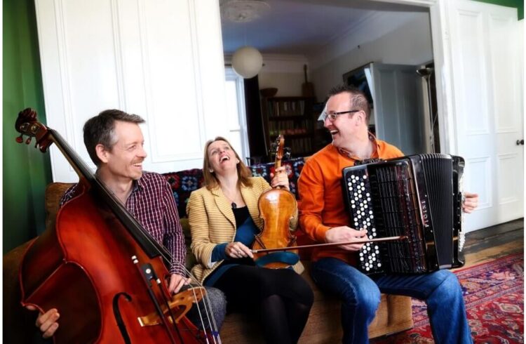 Members of the Far Flung Trio seated on a sofa