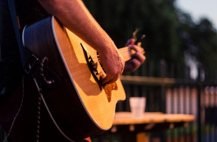 A person playing an acoustic guitar on stage