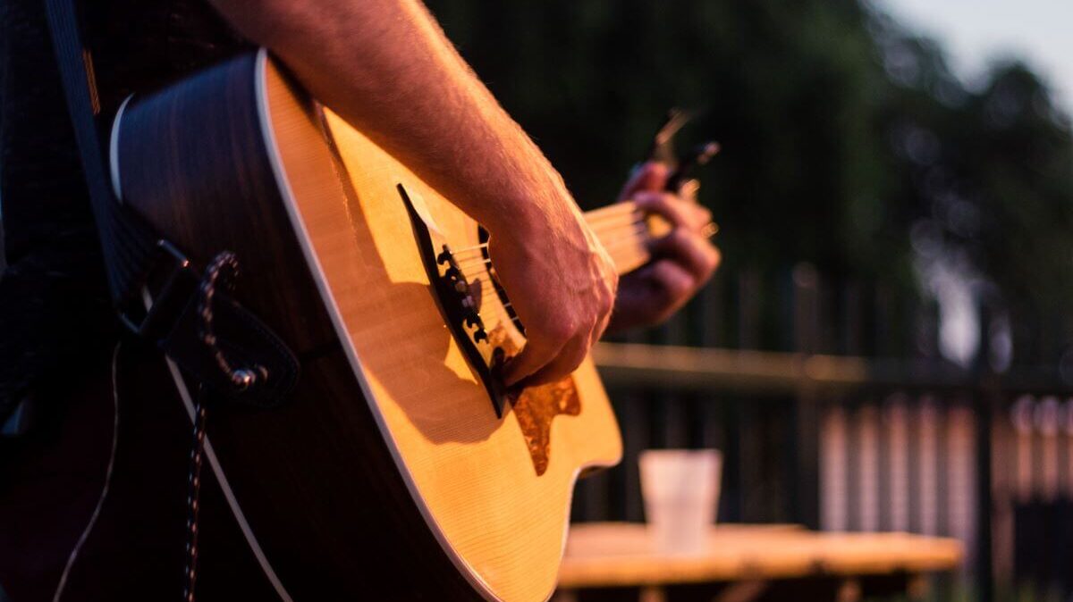 A person playing an acoustic guitar on stage