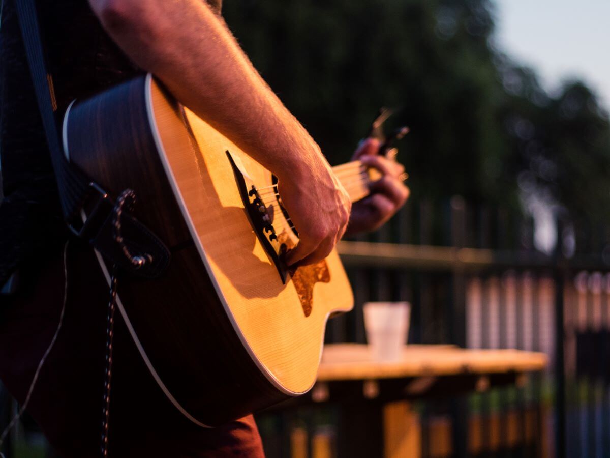 A person playing an acoustic guitar on stage