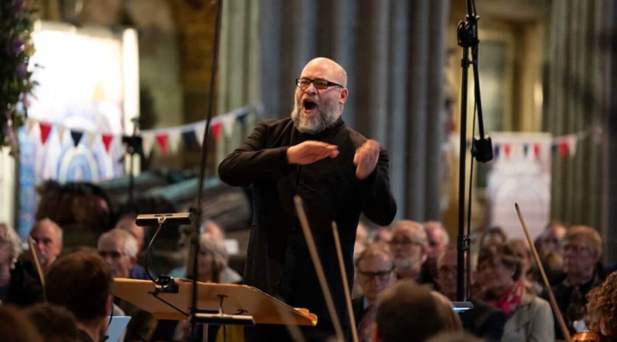 a composer leading an orchestra in a church