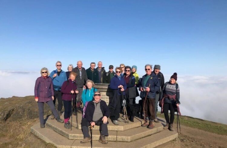 A group of walkers stand on top of a hill