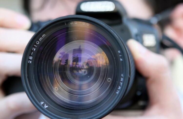 A person holding a camera and lens