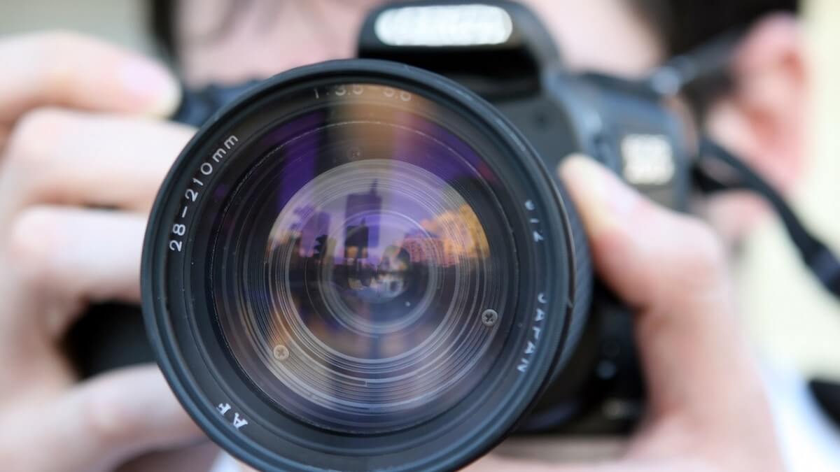 A person holding a camera and lens