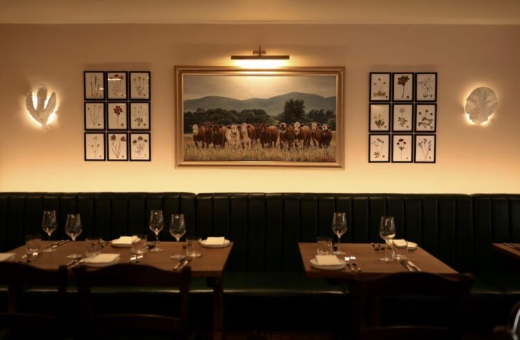 Restaurant interior with green built in seating and cow artwork