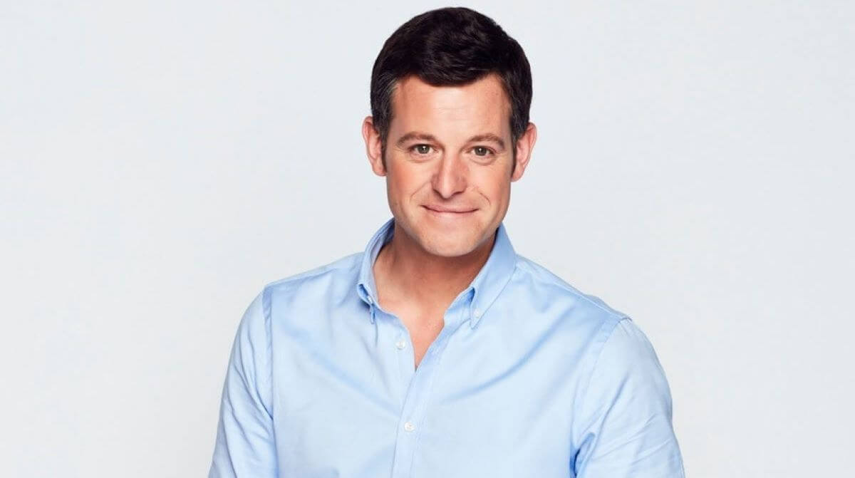 Headshot of a man in a blue shirt