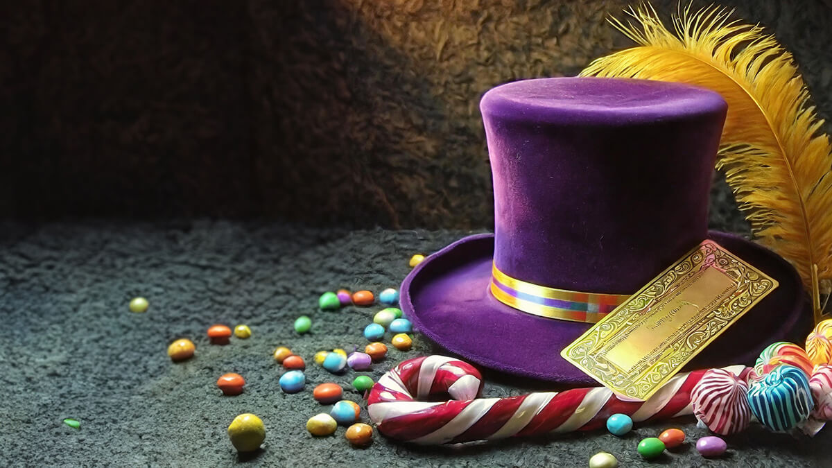 A red-and-white can, purple hat, yellow feather, sweets and a golden ticket