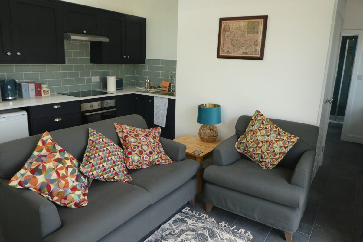 A kitchen diner with a grey kitchen and sofas