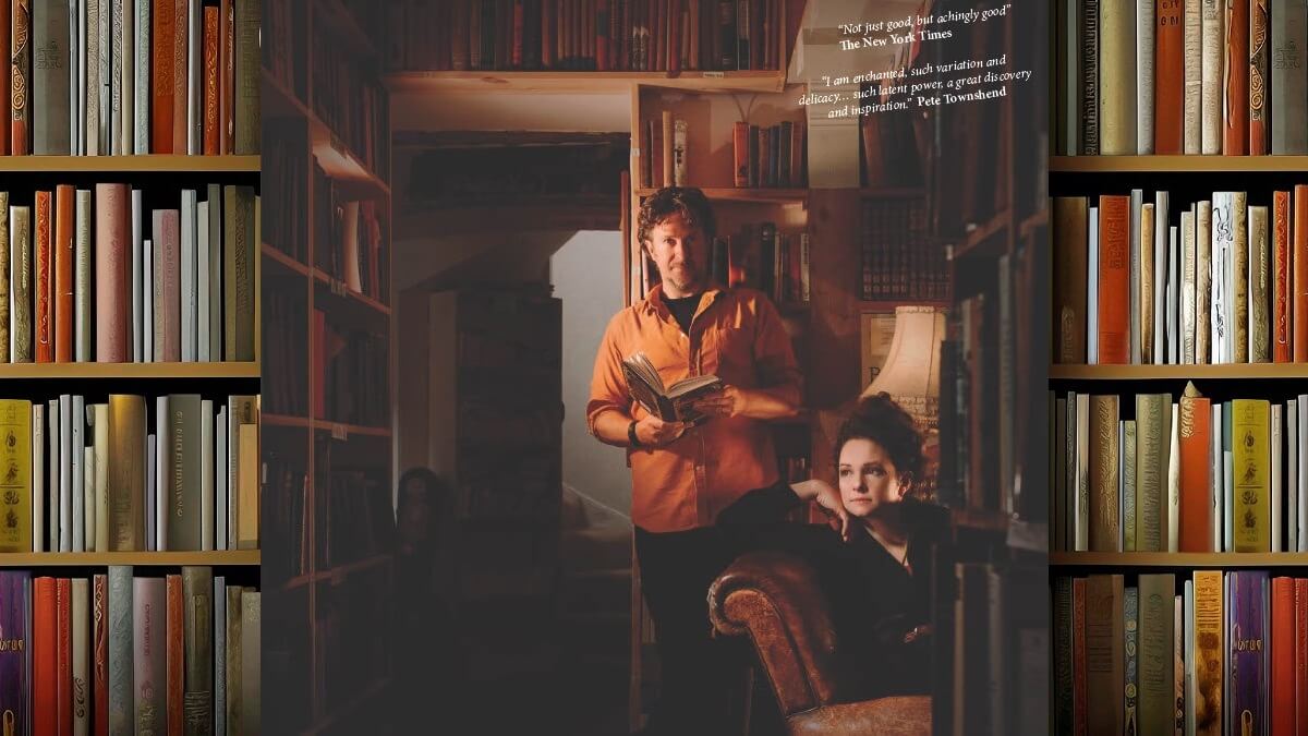 Two members of the band: one seated and one standing in a bookshop