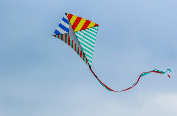 A multicoloured stripy kite flying in the sky