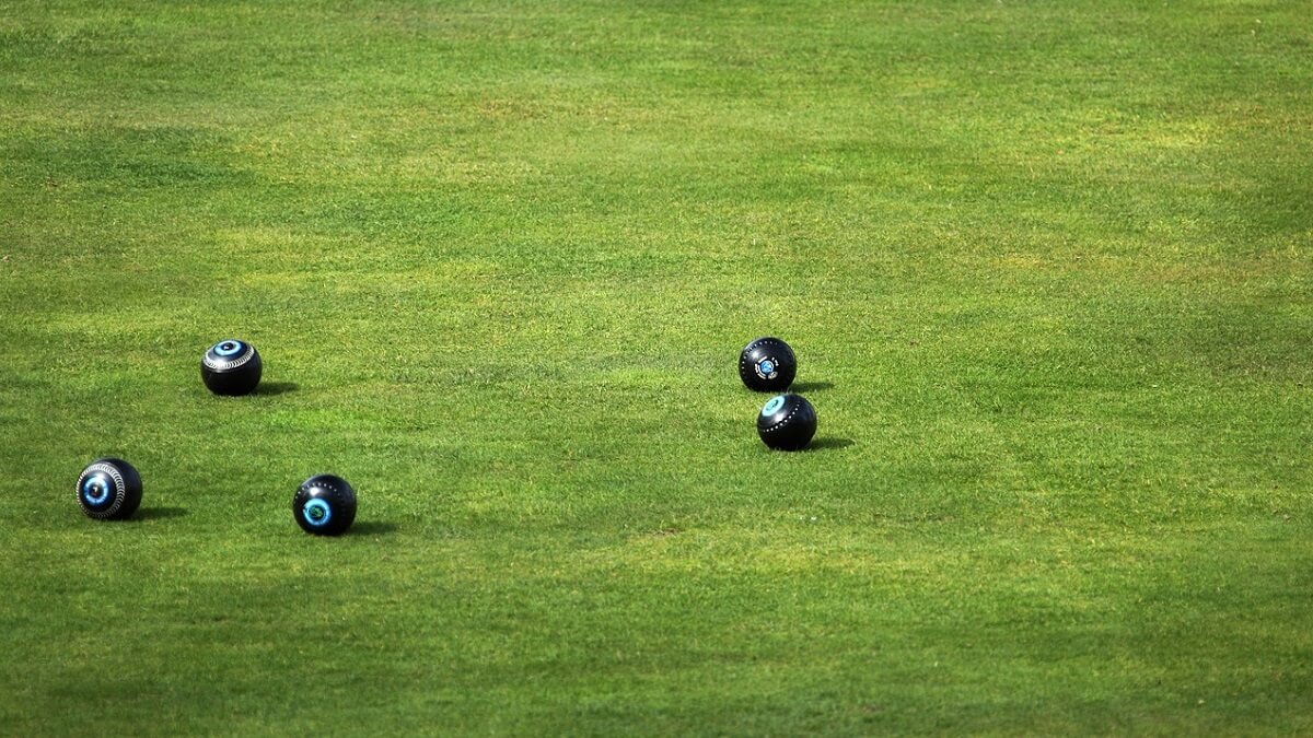 A game of bowls played on a vibrant green lawn