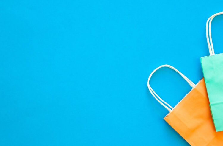 A green and an orange paper bag on a blue background