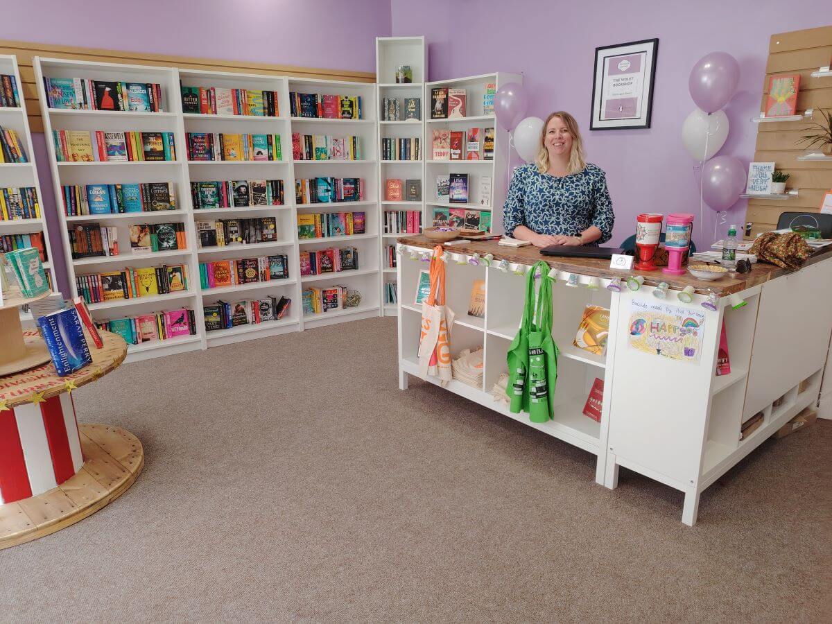 A bookshop with the owner standing behind the counter