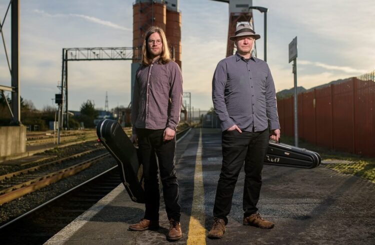 Kit and Aaron standing on a railway platform