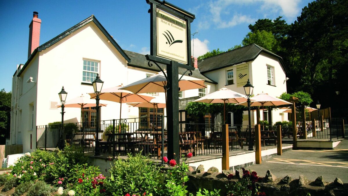 Exterior of the Malvern Hills Hotel including terrace area with tables and parasols