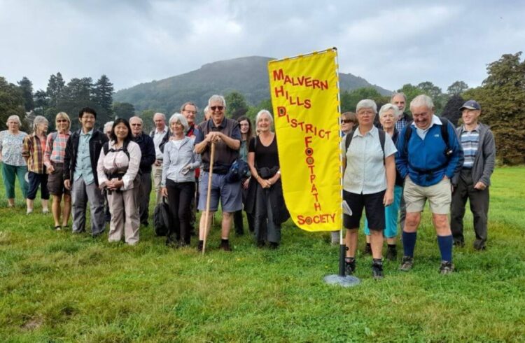 A walking group standing in front of The Malvern Hills