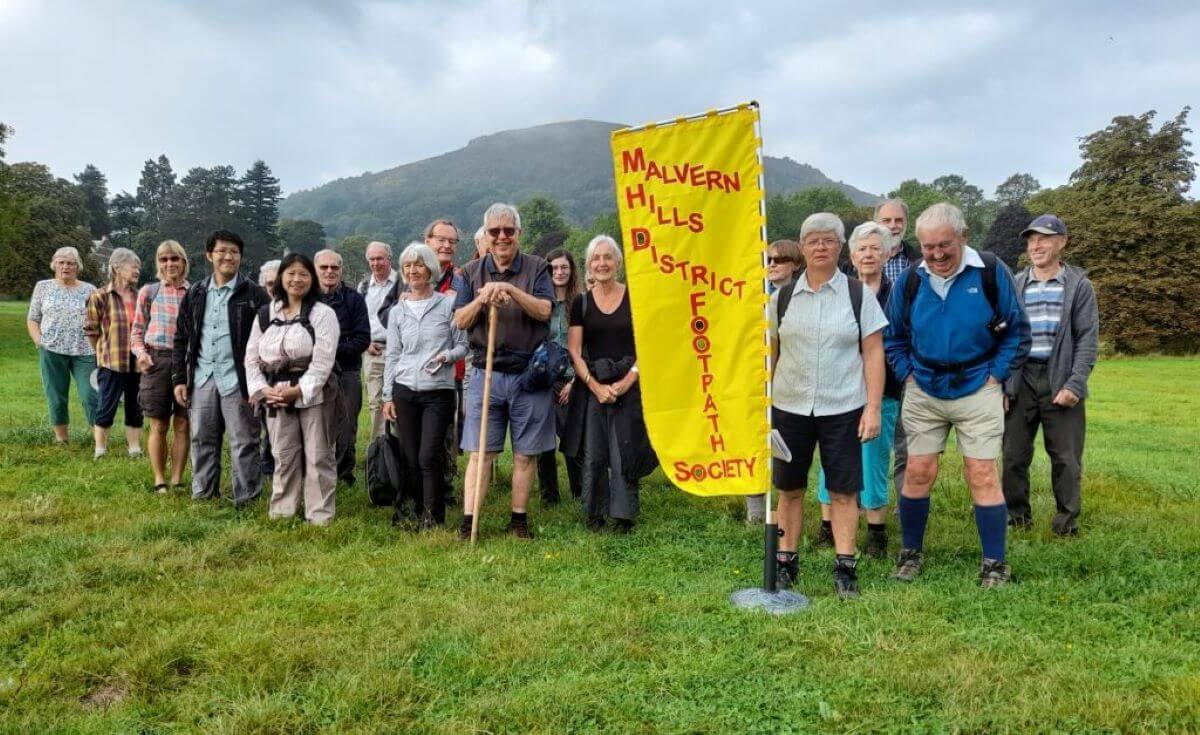 A walking group standing in front of The Malvern Hills