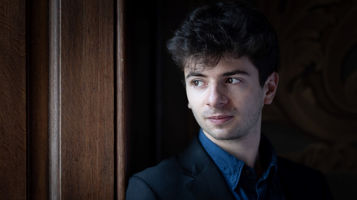 Musician Antoine Preat dressed in a blue shirt and black jacket