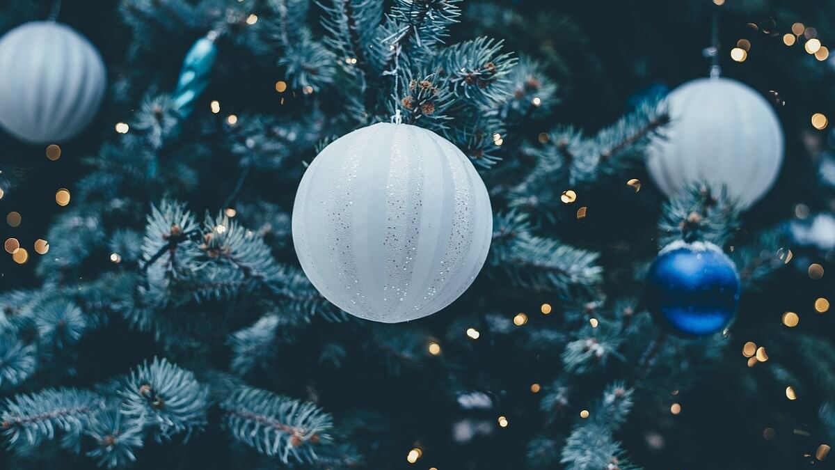 A Christmas tree decorated with glittery white and blue baubles